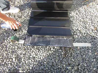 Root barrier sheet material set in a trench alongside hardscape