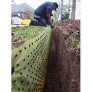 Installer fitting Biobarrier root barrier fabric into a trench along a residential lawn edge

