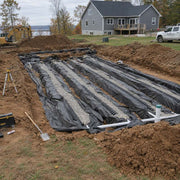 Drainfield fabric lining multiple septic drain field trenches with chamber pipe at a lakeside property
