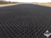 Wide panoramic view of a completed heavy-duty geocell road base installation stretching into the distance
