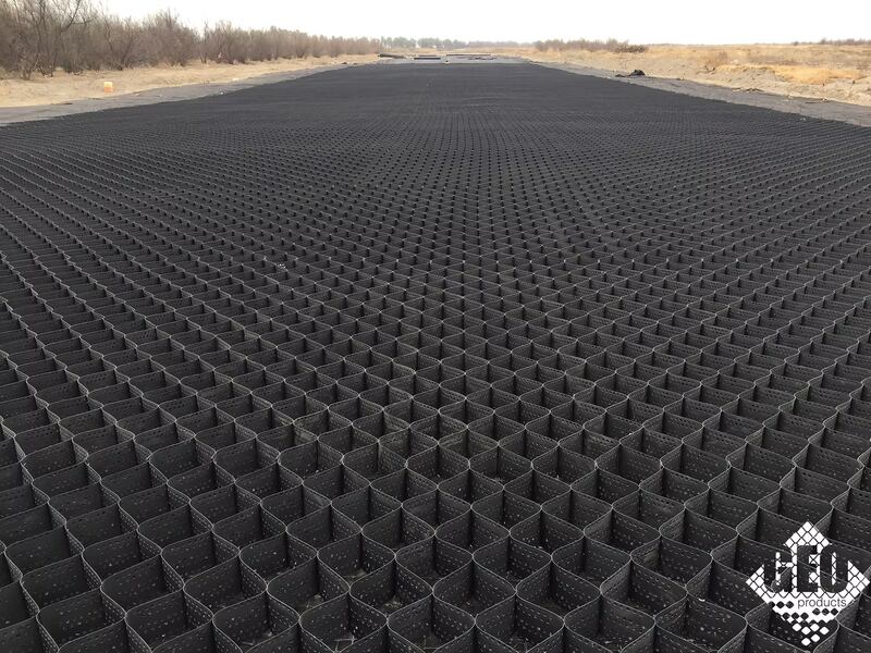 Wide panoramic view of a completed heavy-duty geocell road base installation stretching into the distance
