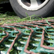 Worker hammering stakes into Tenax GP-Flex 1800 grass protection mesh during installation

