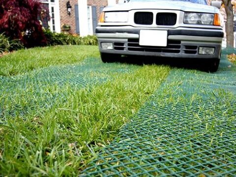 Car parked on a residential lawn reinforced with grass driveway mesh
