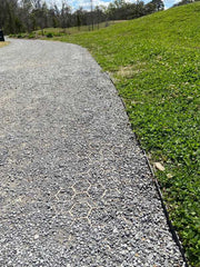 Close-up of the gravel paver grid pattern showing through the stone surface of a park path
