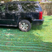 SUV parked on a lawn reinforced with Mudstop grass protection mesh, side view
