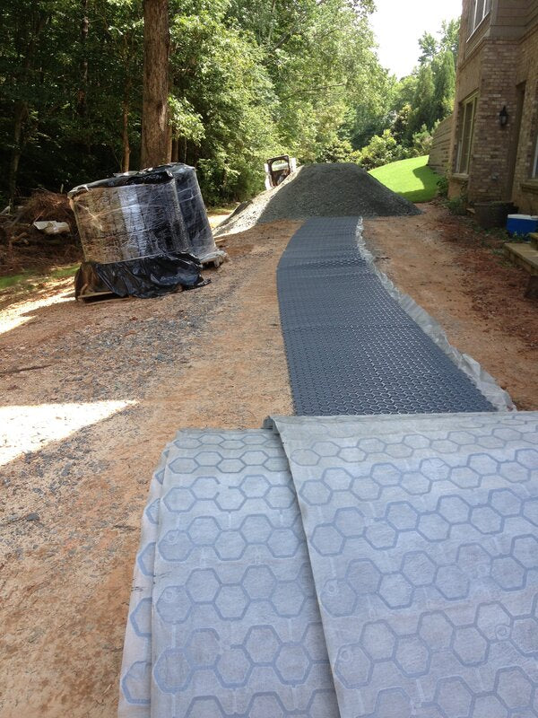 NDS gravel paver grid rolled out over geotextile fabric during driveway prep work

