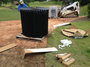 Large roll of NDS gravel paver grid delivered on site next to a skid steer loader
