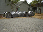 Rolls of NDS gravel paver grid staged on a gravel base before installation at a home
