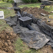 Non-woven geotextile fabric wrapping gravel around a catch basin drain box installation
