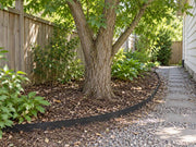 Tree root barrier lining a planting bed along a side yard gravel path
