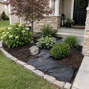 Weed barrier fabric installed in a front entry planting bed with hostas and stone edging
